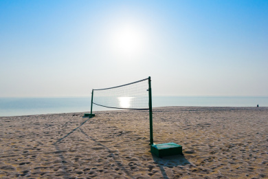 蓝天下海边的沙滩排球场地与球网