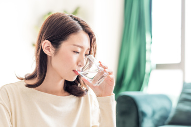 年轻女士拿着水杯喝水