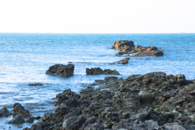 中国海南儋州峨蔓龙门山阳光下的岩石与海