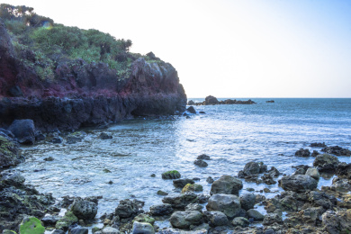 中国海南儋州峨蔓龙门山阳光下的岩石与海