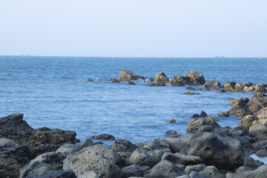 中国海南儋州峨蔓龙门山阳光下的岩石与海