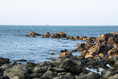 中国海南儋州峨蔓龙门山阳光下的岩石与海