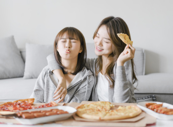 闺蜜一起坐在茶几边吃东西