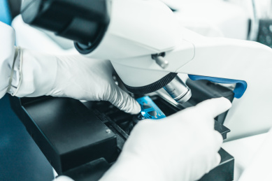 调整显微镜载玻片的手部特写