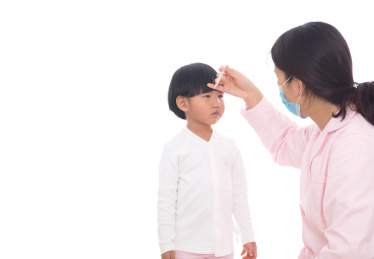 白背景前的女护士在给小女孩测量体温