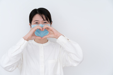 戴着口罩的女生手做爱心手势