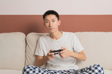 中国男人在客厅沙发上坐着玩游戏