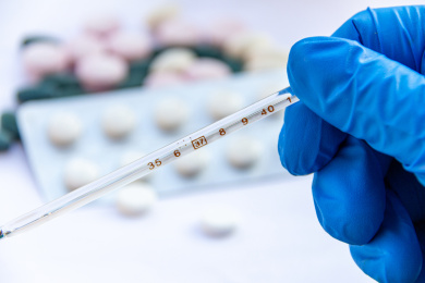 一只手戴蓝色胶手套拿温度计