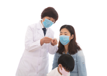 医生拿着温度计在给妈妈和孩子量体温在白背