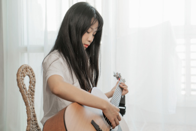 中国年轻女生在卧室弹吉他