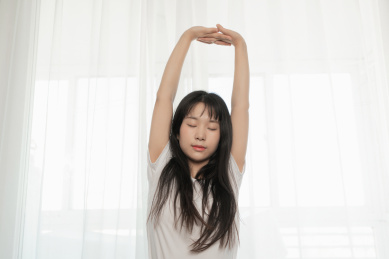 中国年轻女生在卧室伸懒腰