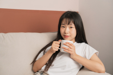 中国年轻女生在家里喝咖啡