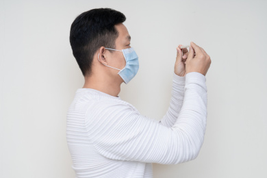 戴口罩的中国男人查看温度计