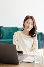 一名年轻女姓在客厅里使用手提电脑进行办公