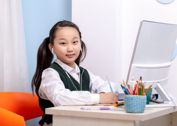 疫情期间在家里通过网络上课学习的小学女生