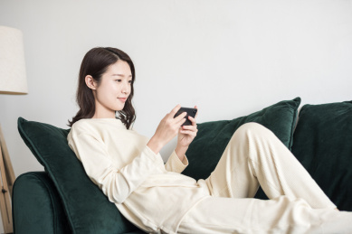 年轻女性宅在家里玩手机游戏