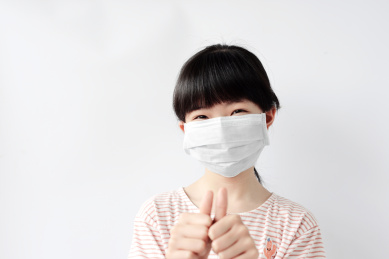 戴口罩的女童在做鼓励的手势