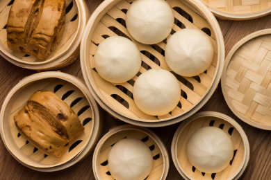 桌子上各种的蒸笼里放着多种包子馒头俯拍