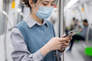 地铁里站着看手机的女生