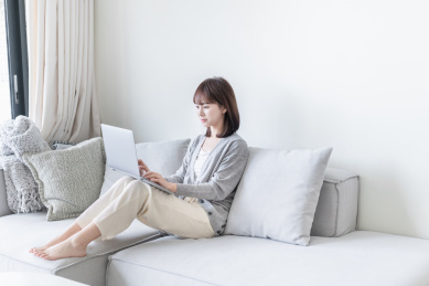 亚洲女生坐在沙发上用电脑办公