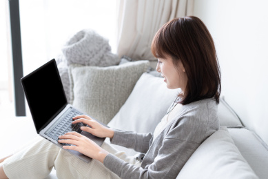 亚洲女生靠在沙发上用电脑办公