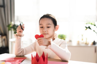 一个人在家做手工剪纸的中国女孩