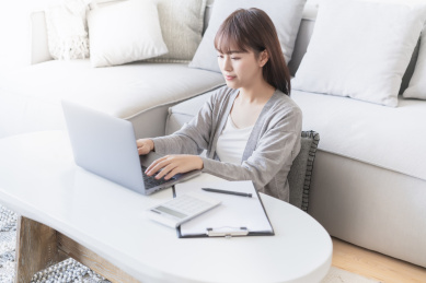 女生在客厅用笔记本电脑办公