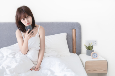 早上不情愿地起床看手机的亚洲女性