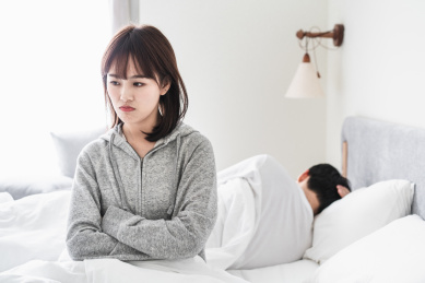 吵架的年轻情侣在床上互相背对