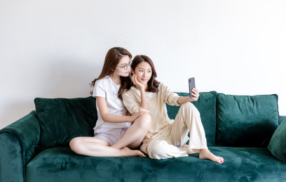 客厅沙发上两个年轻女性在自拍