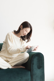 年轻女性坐在沙发上使用平板电脑