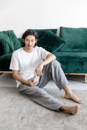 客厅里一名年轻男性拿着手机在思考