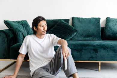 客厅里一名年轻男性拿着手机在思考