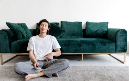 客厅里一名年轻男性拿着手机在思考