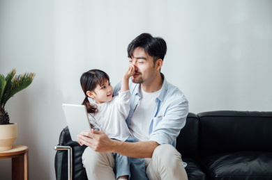 爸爸和女儿在家使用平板电脑