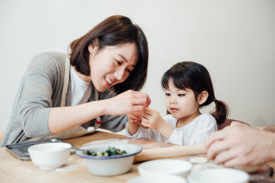 爸爸妈妈和女儿在家包饺子