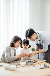 爸爸妈妈和女儿在家包饺子