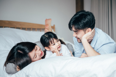 爸爸妈妈和女儿在卧室做游戏