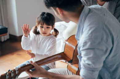 爸爸妈妈和女儿在家唱歌