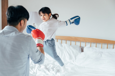 爸爸和女儿在床上打拳击