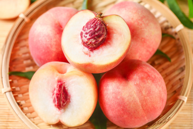 竹垫子上放着一筐阳山水蜜桃和水蜜桃果肉