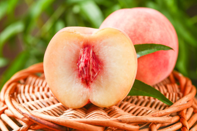 篮子上放着春雪水蜜桃和水蜜桃果肉