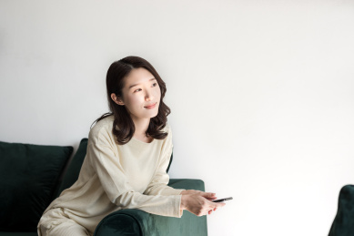 年轻女士拿着手机看着窗外的风景