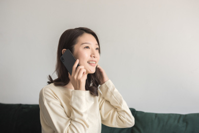 年轻女士坐在沙发上打电话