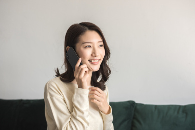 年轻女士坐在沙发上打电话