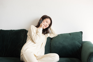 年轻女士坐在沙发上打电话