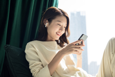 坐在窗台边的年轻女性使用手机