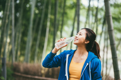 亚洲年轻女孩在户外喝水