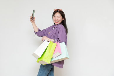 一位年轻的亚洲女性手里拿着购物袋