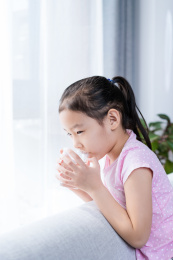 站在窗前喝水休息的中国女孩